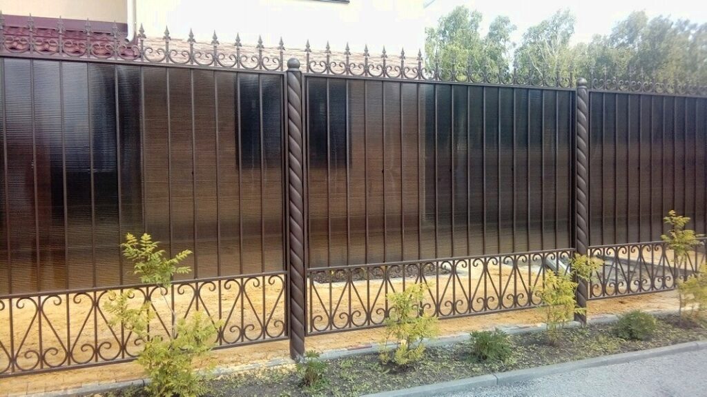 Кованый забор с полупрозрачными панелями из поликарбоната